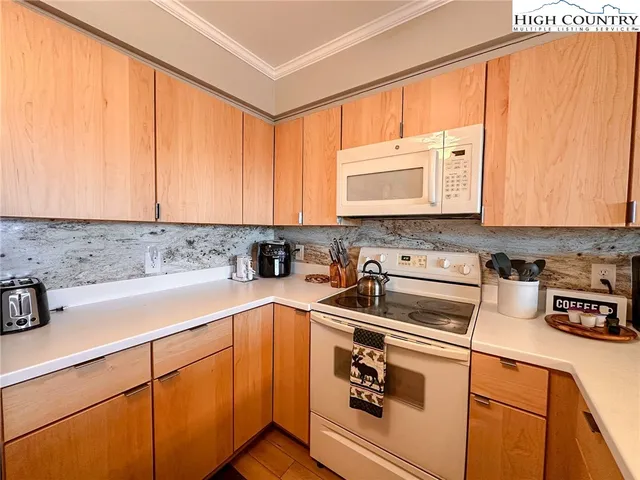 a kitchen with stainless steel appliances granite countertop a sink a stove and white cabinets