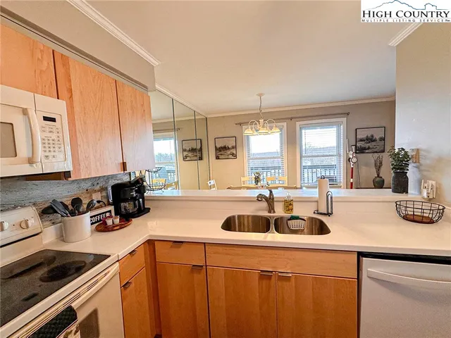 a kitchen with a sink a counter appliances and cabinets