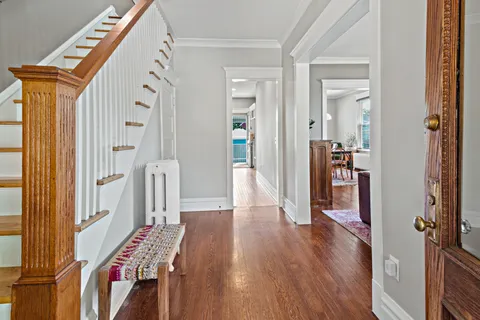 a view of a hallway with wooden floor and stairs
