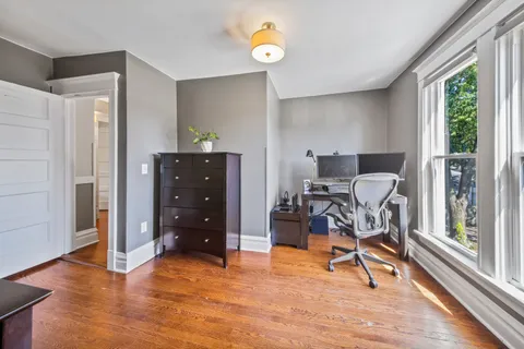 a view of a workspace with furniture and a window