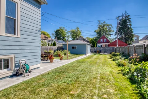 a view of a backyard with plants and chairs
