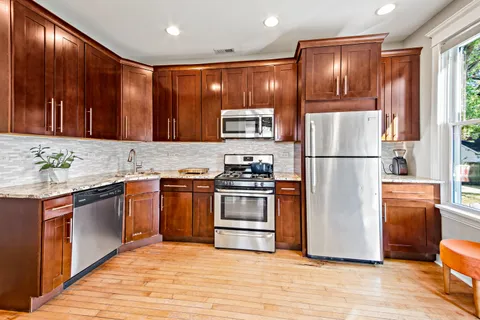 a kitchen with stainless steel appliances granite countertop a refrigerator stove and sink
