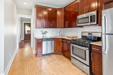 a kitchen with stainless steel appliances granite countertop wooden cabinets and a stove top oven
