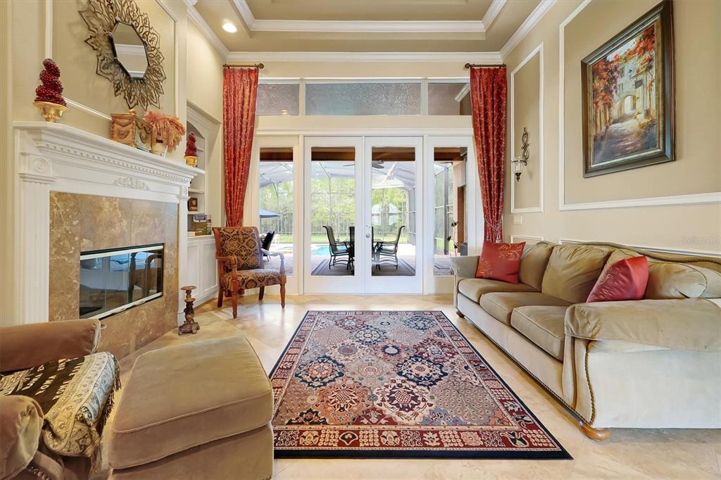 12012 Rambling Oak Boulevard Orlando, FL 32832 - Photo 13 of 49 a living room with furniture a fireplace and a floor to ceiling window