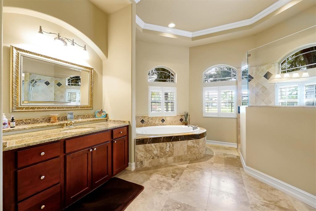 12012 Rambling Oak Boulevard Orlando, FL 32832 - Photo 20 of 49 a bathroom with a double vanity sink toilet mirror and bathtub