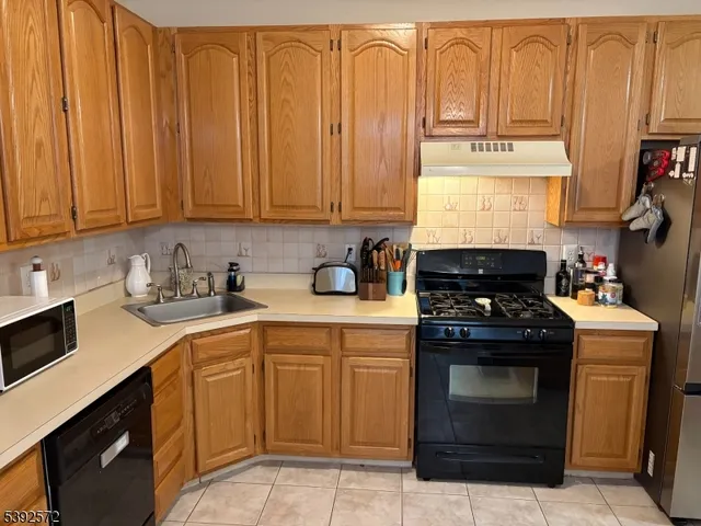 a kitchen with stainless steel appliances granite countertop a stove a sink and dishwasher