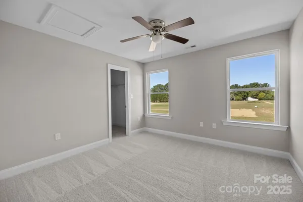 an empty room with closet and a chandelier fan