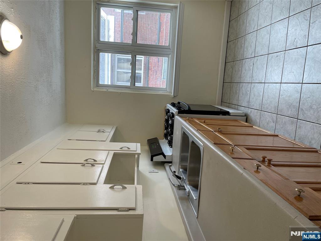 138 Midland Place, Unit 2 Newark, NJ 07106 - Photo 5 of 6 a kitchen with a sink stove and cabinets