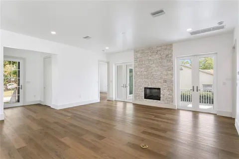 an empty room with wooden floor and fireplace