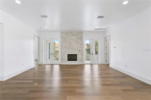 an empty room with wooden floor and fireplace