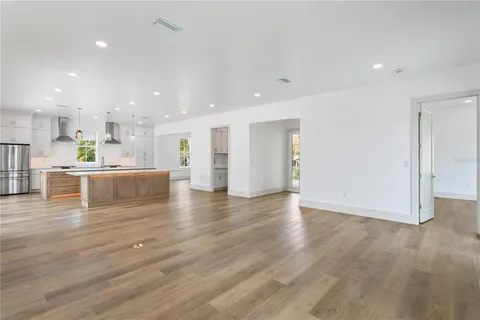a large kitchen with stainless steel appliances kitchen island a large counter top and a floors