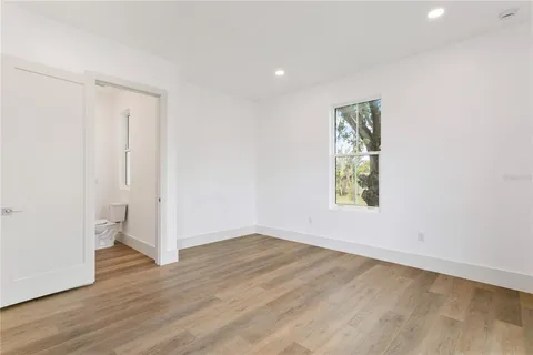 an empty room with wooden floor and window