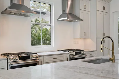 a kitchen with kitchen island a stove a sink and a wooden floors