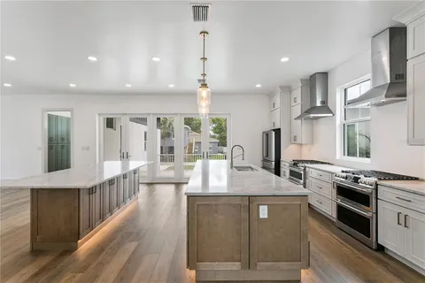an empty room with wooden floor fireplace and windows