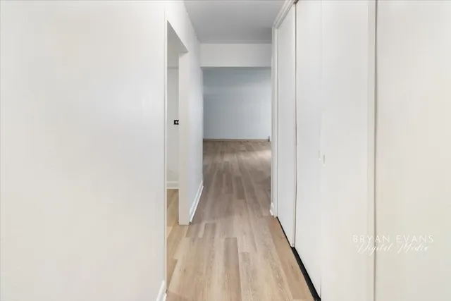 a view of a hallway with wooden floor