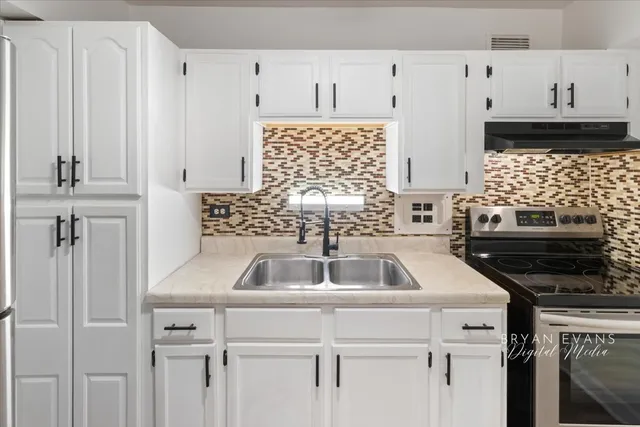 a kitchen with a sink stove and cabinets