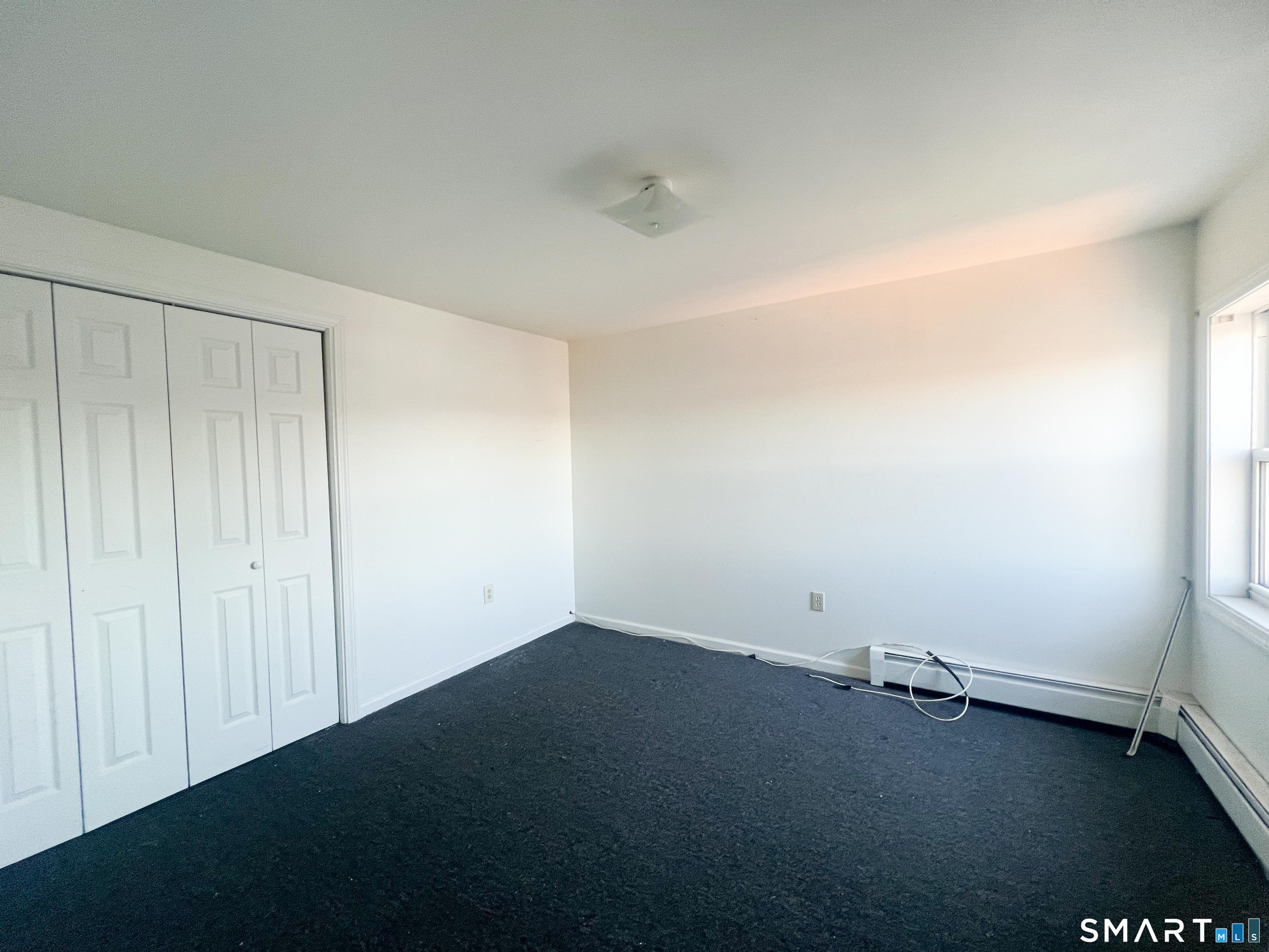 99 William Street, Unit B Bridgeport, CT 06608 - Photo 12 of 16 an empty room with a wooden door