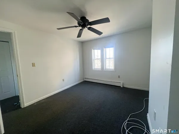 an empty room with a window and a ceiling fan