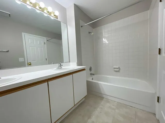 a bathroom with a tub a sink and mirror