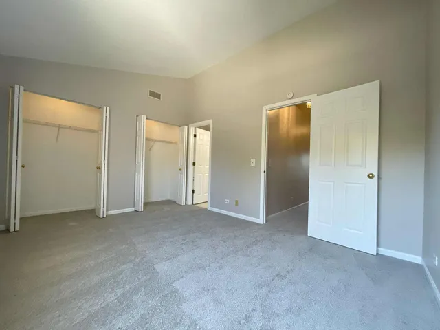 an empty room with closet and a bathroom