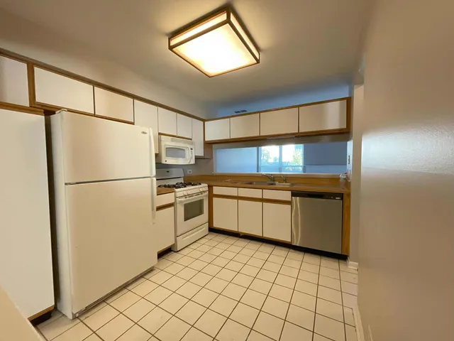 a kitchen with a refrigerator sink and cabinets
