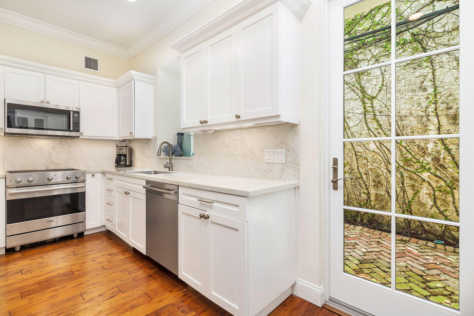 135 Root Trail, Unit A Palm Beach, FL 33480 - Photo 11 of 25 a kitchen with granite countertop white cabinets and white appliances