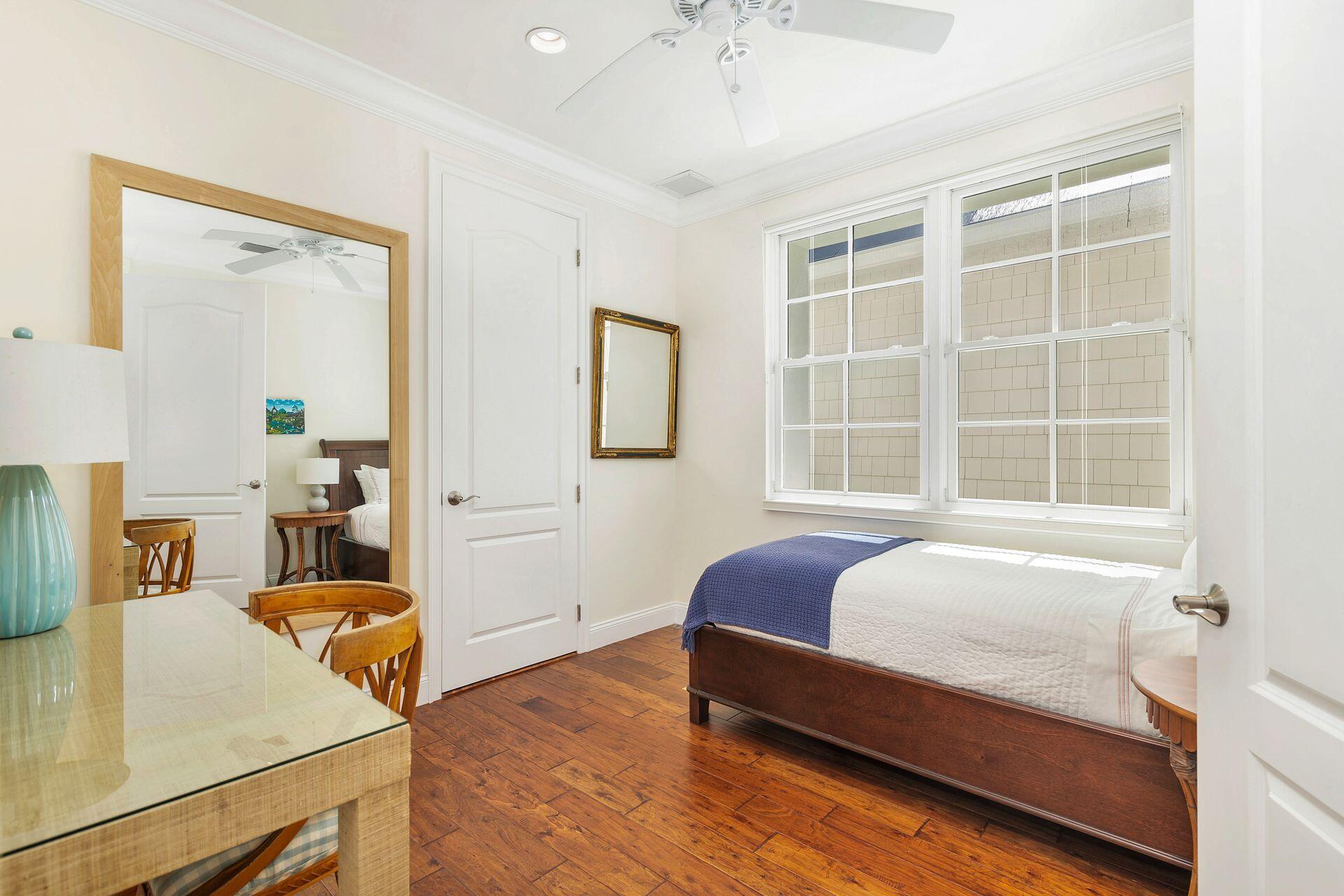 135 Root Trail, Unit A Palm Beach, FL 33480 - Photo 17 of 25 a bedroom with a bed and wooden floor