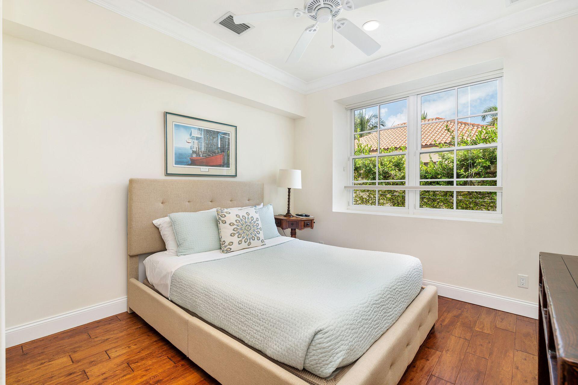 135 Root Trail, Unit A Palm Beach, FL 33480 - Photo 19 of 25 a bedroom with a large bed and a window