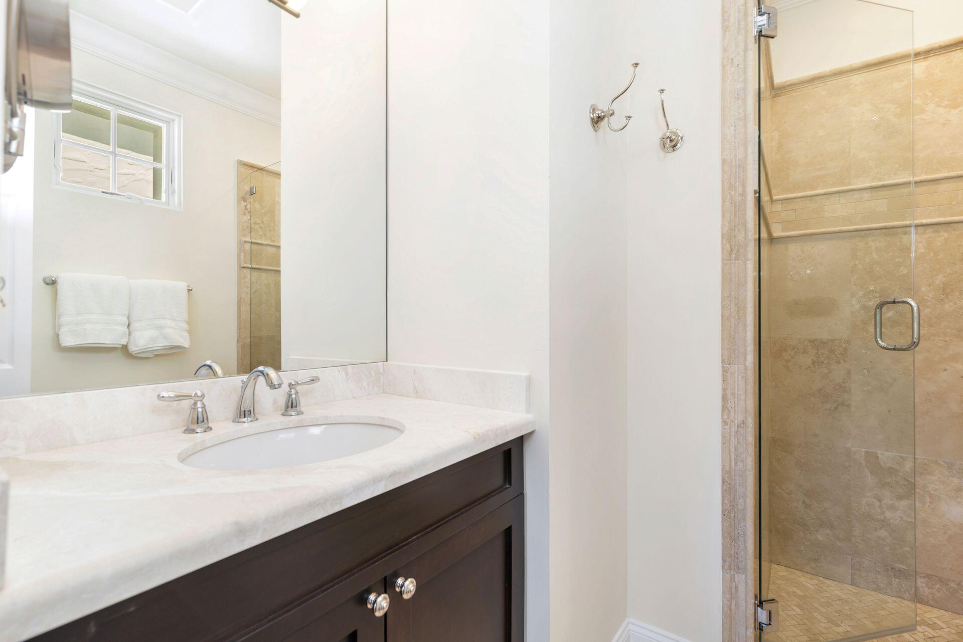 135 Root Trail, Unit A Palm Beach, FL 33480 - Photo 20 of 25 a bathroom with a sink and a mirror
