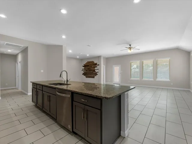 a kitchen with stainless steel appliances granite countertop a sink and a stove