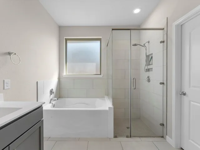 a bathroom with a bathtub a shower and a sink