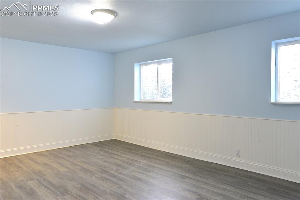 575 Blossom Field Road Fountain, CO 80817 - Photo 16 of 24 an empty room with wooden floor and windows