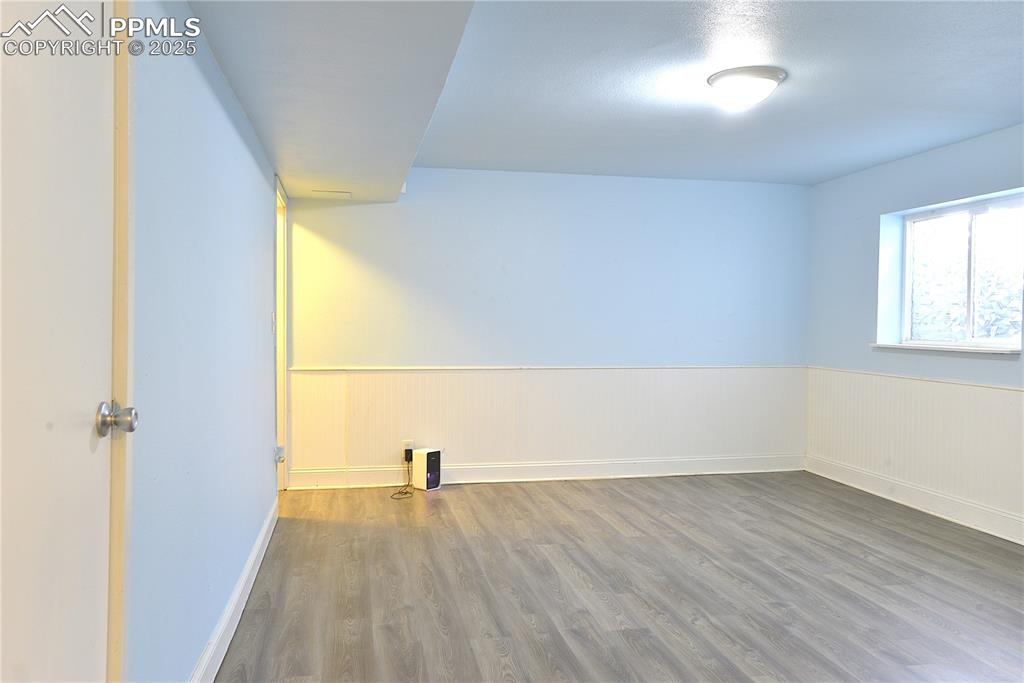 575 Blossom Field Road Fountain, CO 80817 - Photo 18 of 24 an empty room with wooden floor and windows