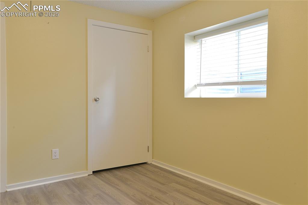 575 Blossom Field Road Fountain, CO 80817 - Photo 21 of 24 an empty room with wooden floor and windows