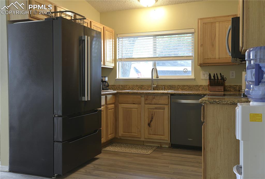 575 Blossom Field Road Fountain, CO 80817 - Photo 7 of 24 a kitchen with a sink a refrigerator and cabinets