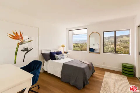 a bedroom with a bed and a large window