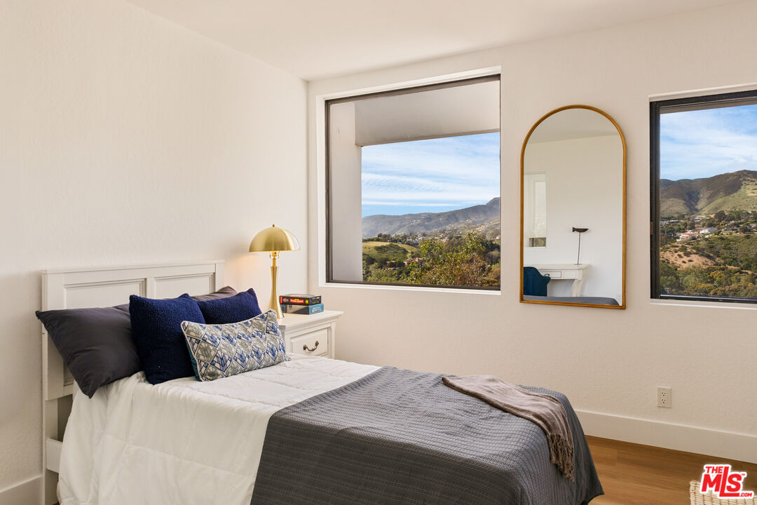 29221 Heathercliff Road, Unit 13 Malibu, CA 90265 - Photo 27 of 43 a bedroom with a bed and a large window