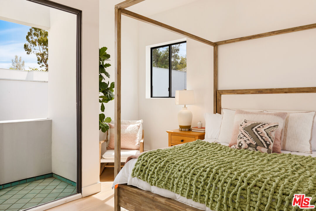 29221 Heathercliff Road, Unit 13 Malibu, CA 90265 - Photo 34 of 43 a bedroom with a bed and a table