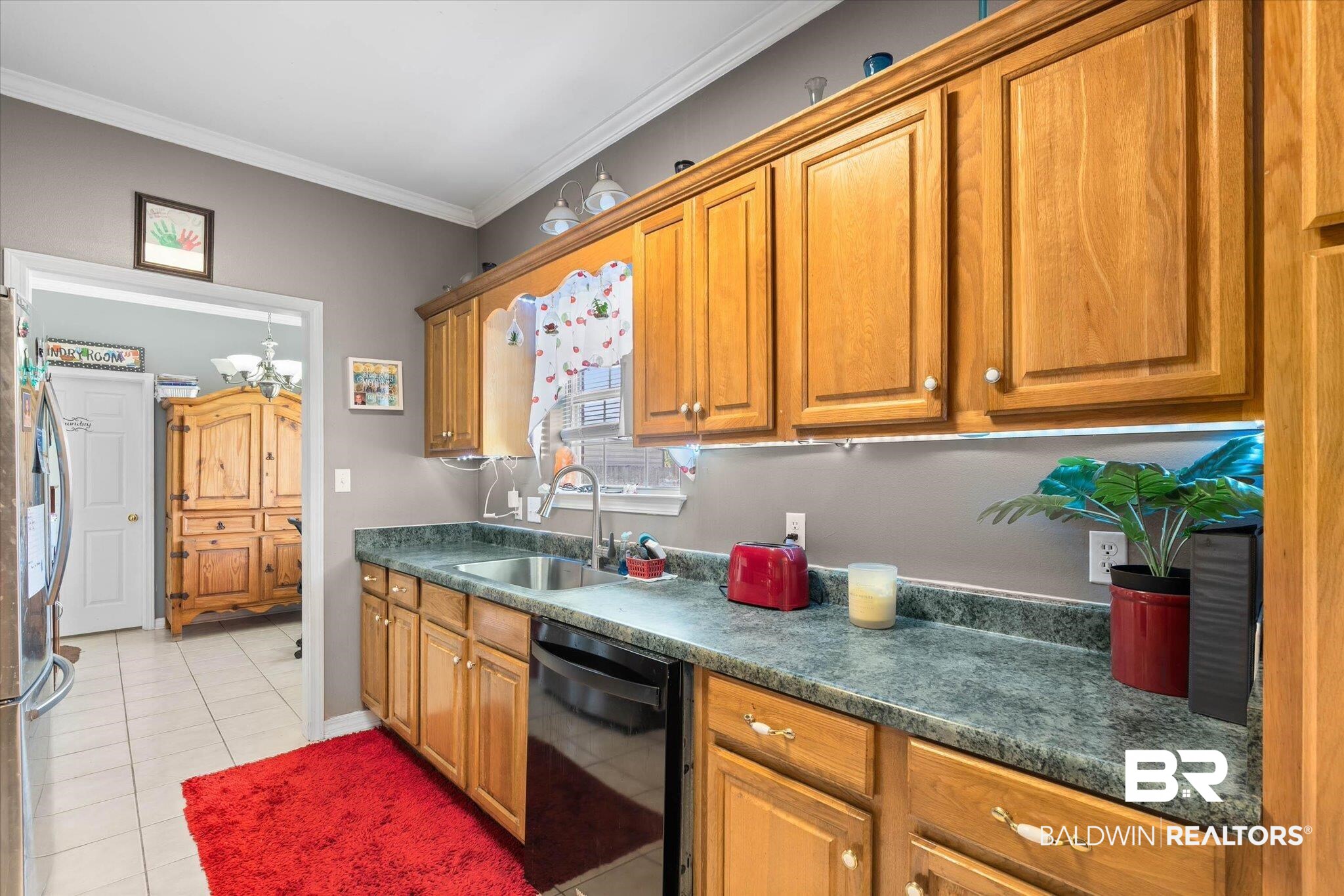 22095 Buck Road Robertsdale, AL 36567 - Photo 7 of 22 Kitchen with dark countertops, dishwasher, wood finish cabinetry, crown molding, and freestanding refrigerator