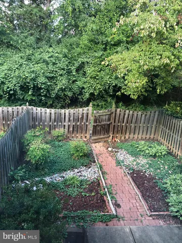 a view of garden with wooden fence