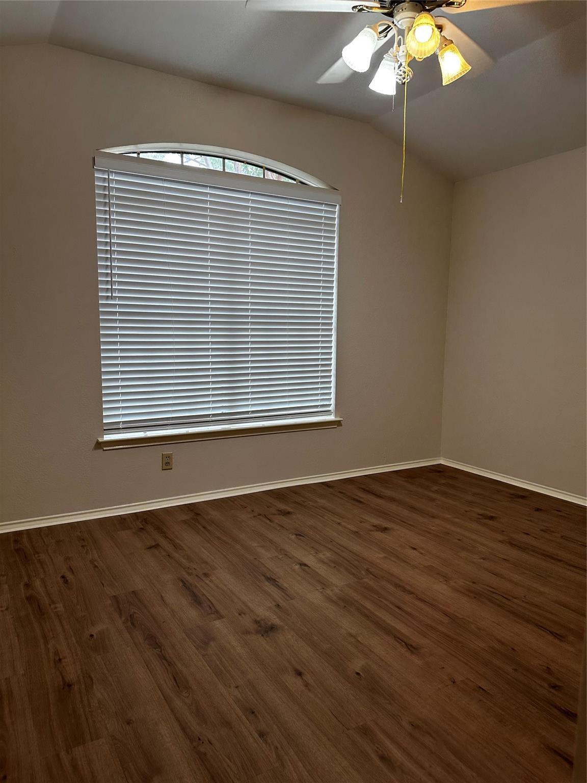 8007 Bounty Trail Austin, TX 78749 - Photo 29 of 32 Wood flooring and vaulted ceilings create a spacious and inviting ambiance in this well-lit room.