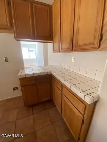 a kitchen with granite countertop a sink a stove and cabinets