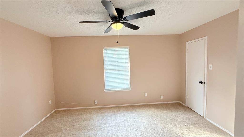 12259 Rim Rock Road Dallas, TX 75253 - Photo 14 of 17 Unfurnished room with a textured ceiling, light carpet, and ceiling fan