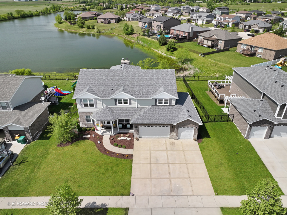 an aerial view of a house with outdoor space and lake view
