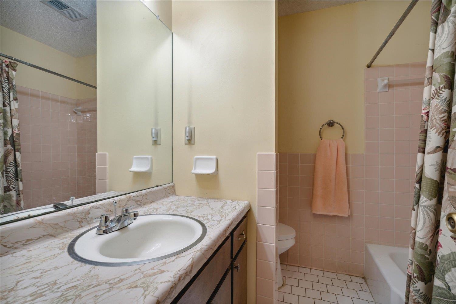 4839 Yale Road Memphis, TN 38128 - Photo 23 of 27 Full bathroom featuring shower / tub combo with curtain, vanity, tile patterned floors, toilet, and tile walls