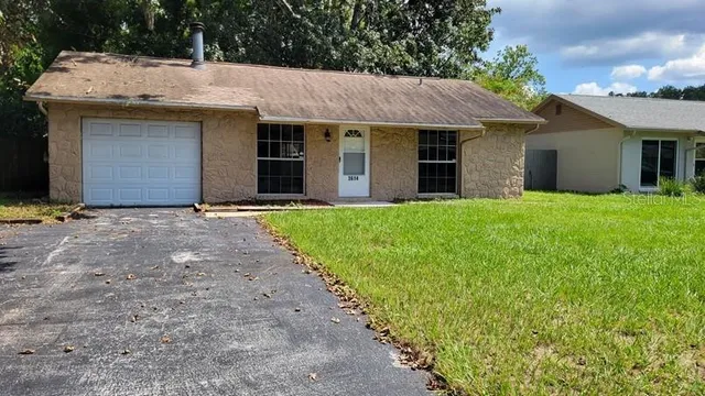 a front view of a house with yard and trees