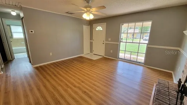 an empty room with wooden floor and windows