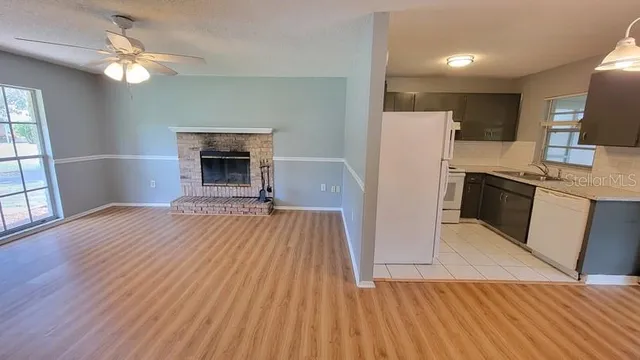 a view of a kitchen with wooden floor and a ceiling fan