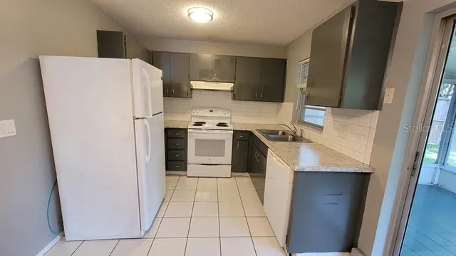 a kitchen with a refrigerator sink stove and cabinets