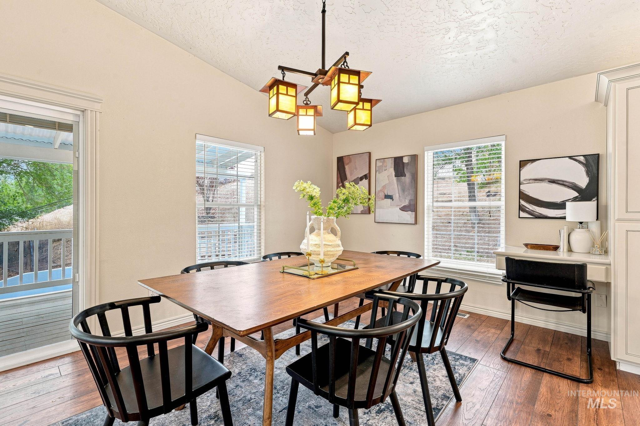 2442 West Hill Road Boise, ID 83702 - Photo 11 of 48 Wood-finish flooring throughout, featuring a multi-light ceiling fixture, multiple windows with blinds, and white built-in cabinetry